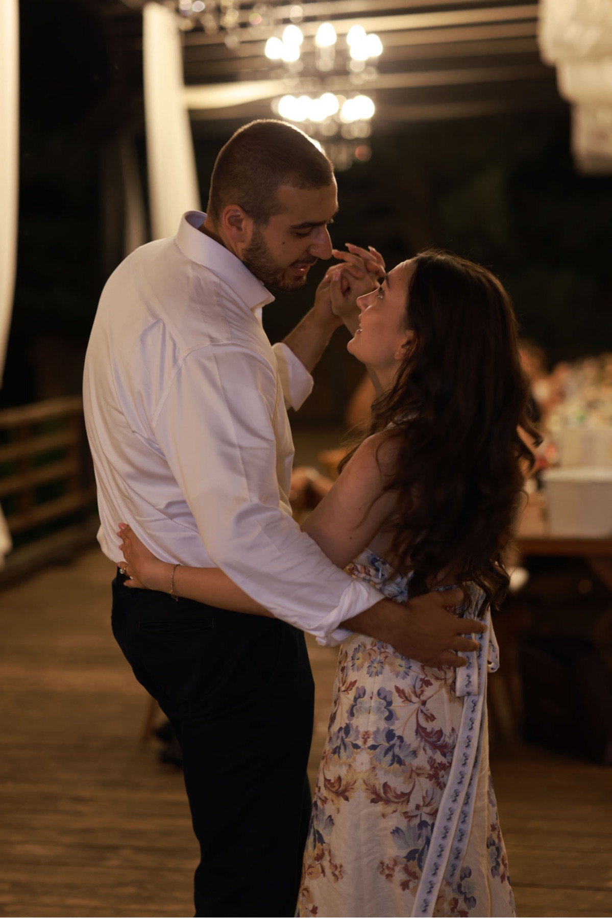 David and Gareene sharing a slow dance under the lights at their wedding reception